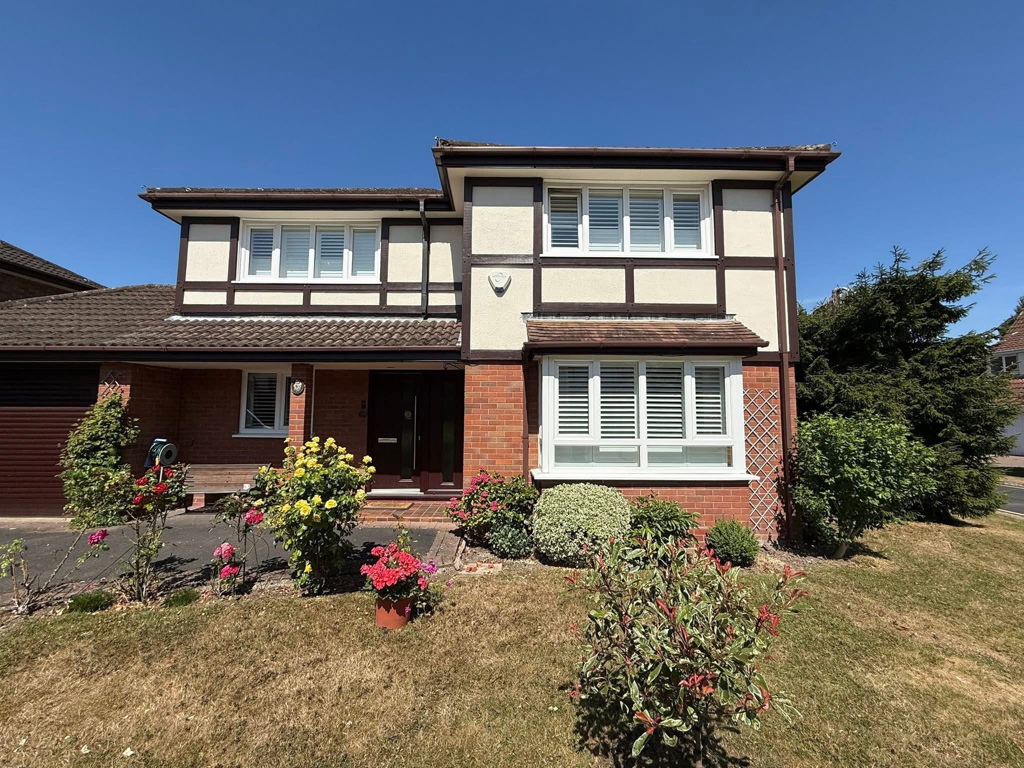 Exterior painting project — Tudor-style detached house with cream and brown facade